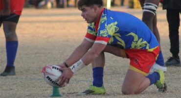 A rugby player sets the ball for a conversion kick