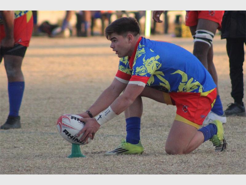 A rugby player sets the ball for a conversion kick