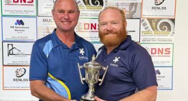 Two men in blue and white sport clothes hold up a trophy