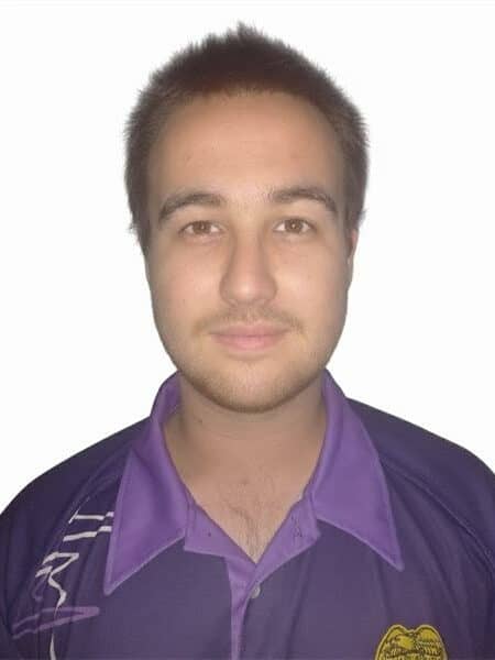 Young man in purple shirt with a neutral background.ey hair