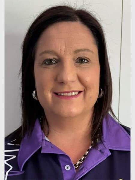 dark haired woman in a navy and purple chaplaincy shirt
