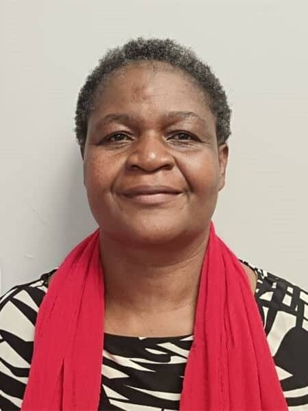 Close-up image of a black woman, wearing a black and white striped top and a red scarf.