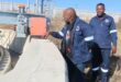 Two men inspect a sewer plant