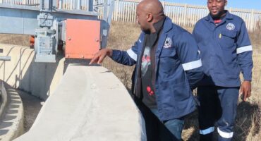 Two men inspect a sewer plant