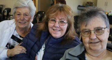 three elderly women sitting next to one another