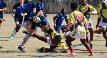 two teams tackle each other on the rugby field