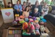 a group of women with crocheted squares