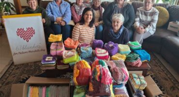 a group of women with crocheted squares