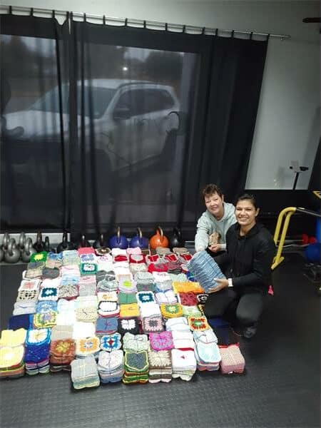 Two women with crocheted squares
