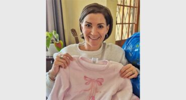 a woman holds up a set of pajamas for a girl