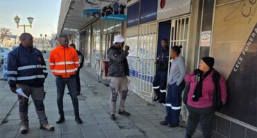 people stand around outside a store