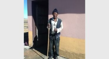 old man sweeps sewage from his house
