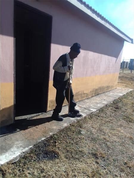 old man sweeps sewage from his house