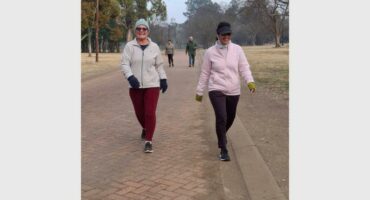 two women walking on a dirt road