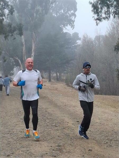 two men running on a dirt road