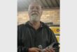 man holds a homing pigeon in his hands