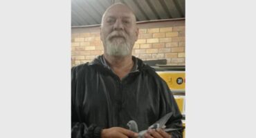 man holds a homing pigeon in his hands