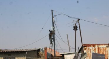people climbing on electricity poles