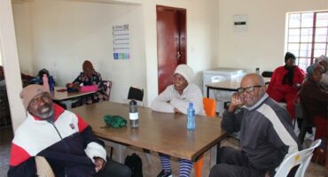 elderly people sitting around a table