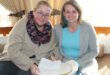 two women study instructions on a paper