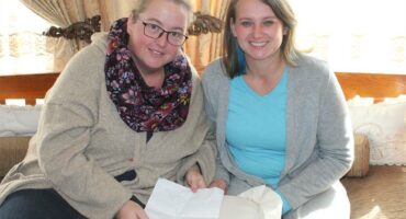 two women study instructions on a paper