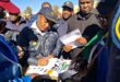 a police woman signs memorandum surrounded by people