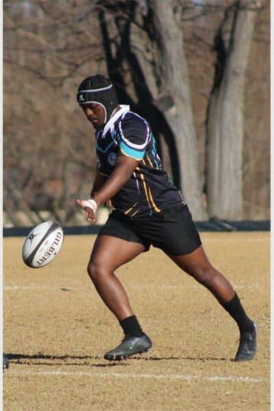 a rugby player kicks the ball