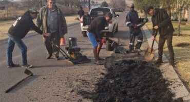 people work to fill up potholes