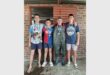 four boys with medals around their necks