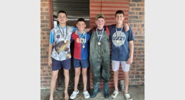 four boys with medals around their necks