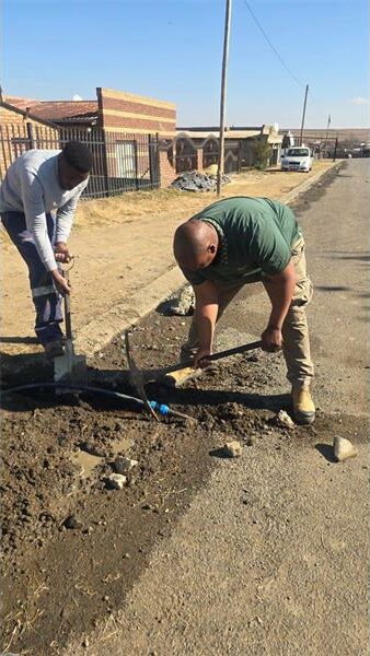 a man repairs a water leak in the street