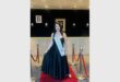 a woman in a black dress standing on a red carpet
