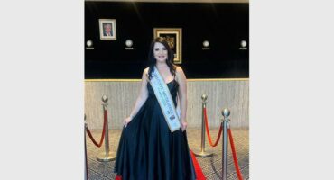 a woman in a black dress standing on a red carpet