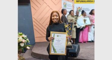 woman in a black outfit holds up a certificate