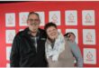 a man and a woman hugging in front of a blood bank back drop