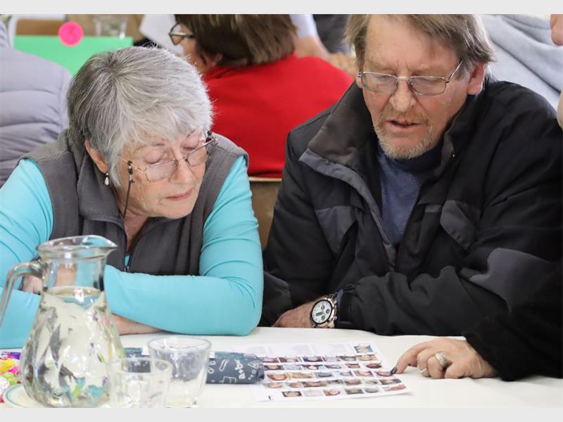 a couple stare at a a page with photos