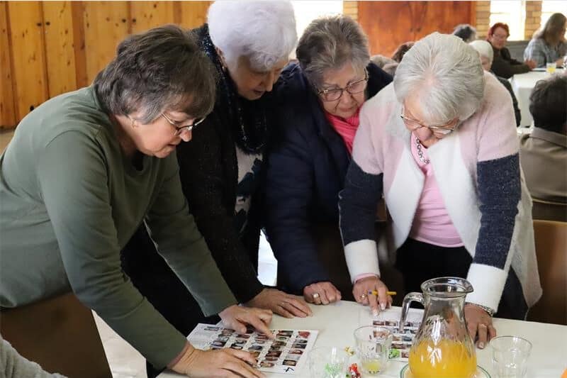 women stare at a a page with photos