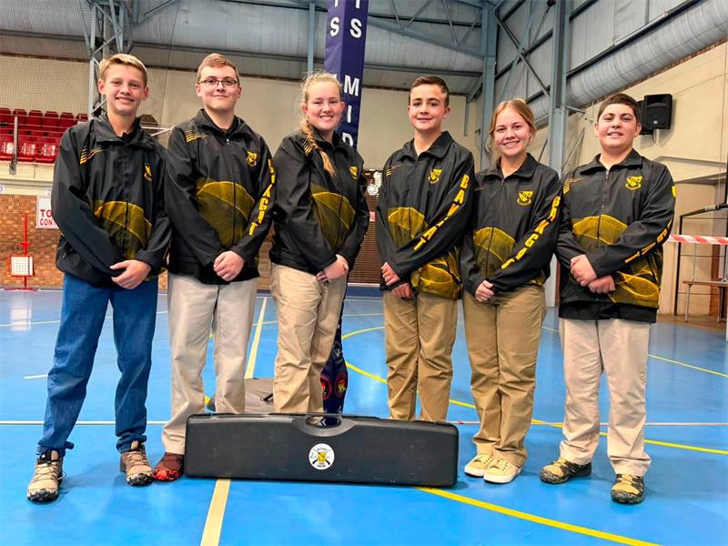 Six young people wearing the same outfit