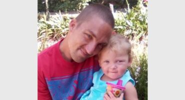 a man hold n little girl in his arms