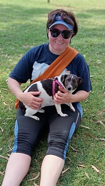 a woman with sunglasses and a dog on her lap