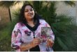 an indian woman holding up a book