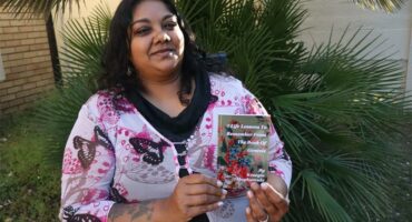 an indian woman holding up a book