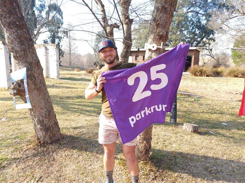a man with a purple flag with the number 25 on it