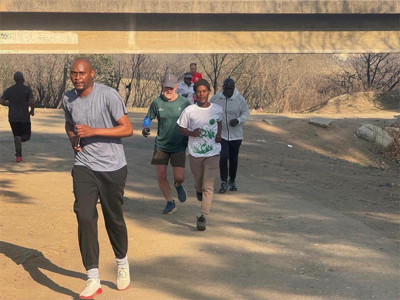 people jogging in a dirt road outside