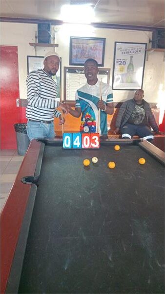 men standing at a pool table
