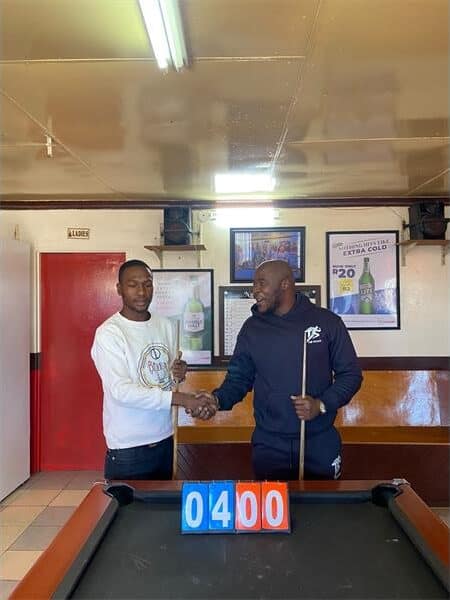 two men standing at a pool table