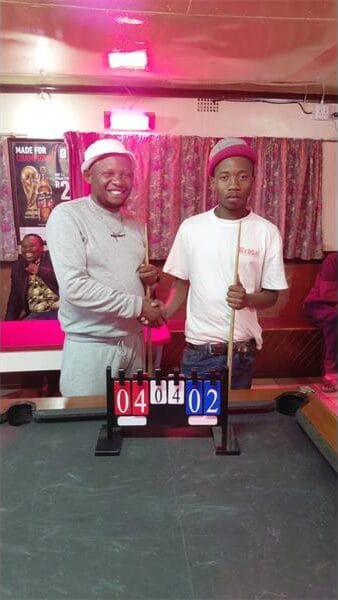 two men standing at a pool table