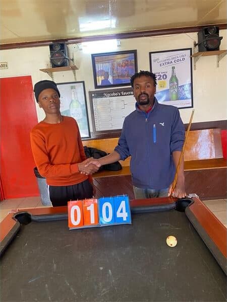 two men standing at a pool table