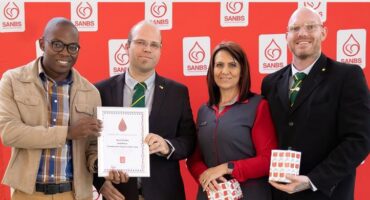 Four people with certificates from the national blood services