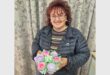 a woman holding a bouquet of cupcakes